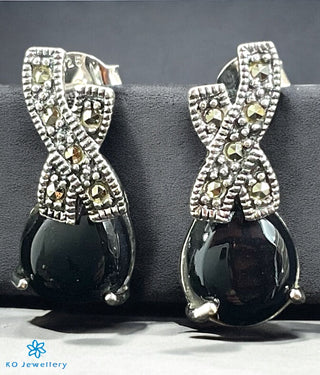 Kaveesha Silver Marcasite Cocktail Earrings with large black gemstones on a gray display