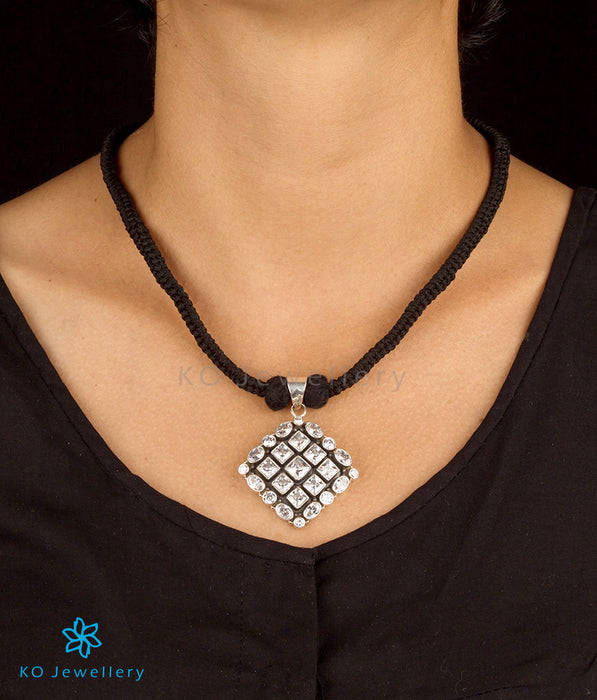 An ethnic silver pendant in a matching black thread for regular wear